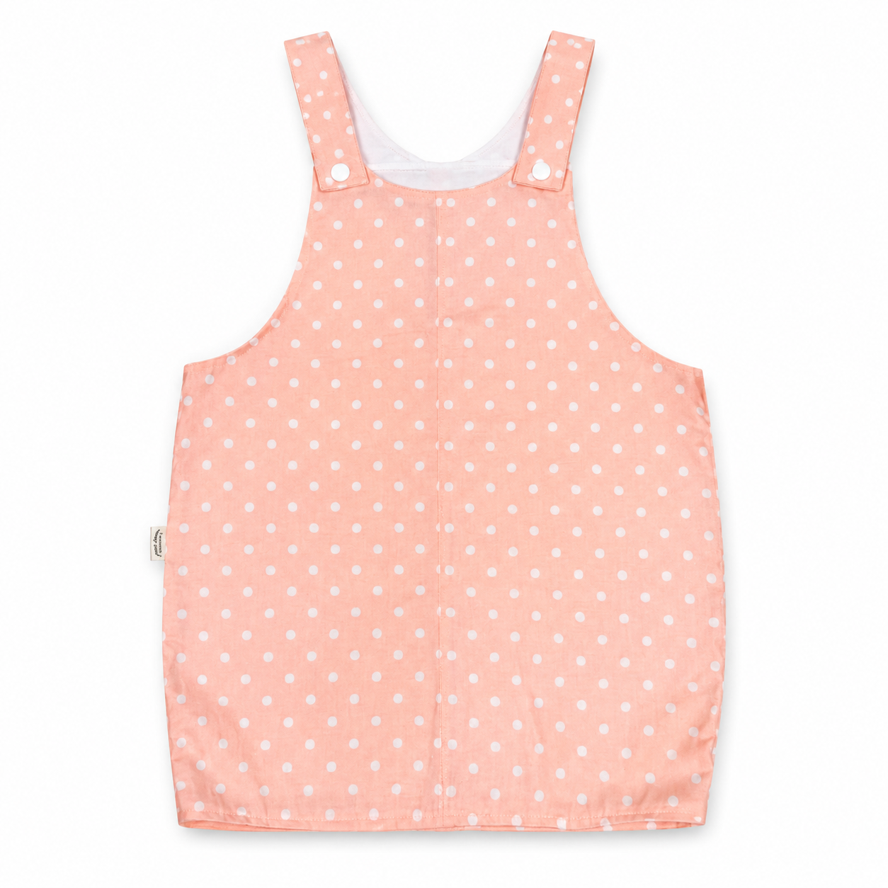 A sleeveless baby romper in a light peach-pink color with a white polka dot pattern, featuring adjustable shoulder straps with snap buttons, shown flat on a white background.