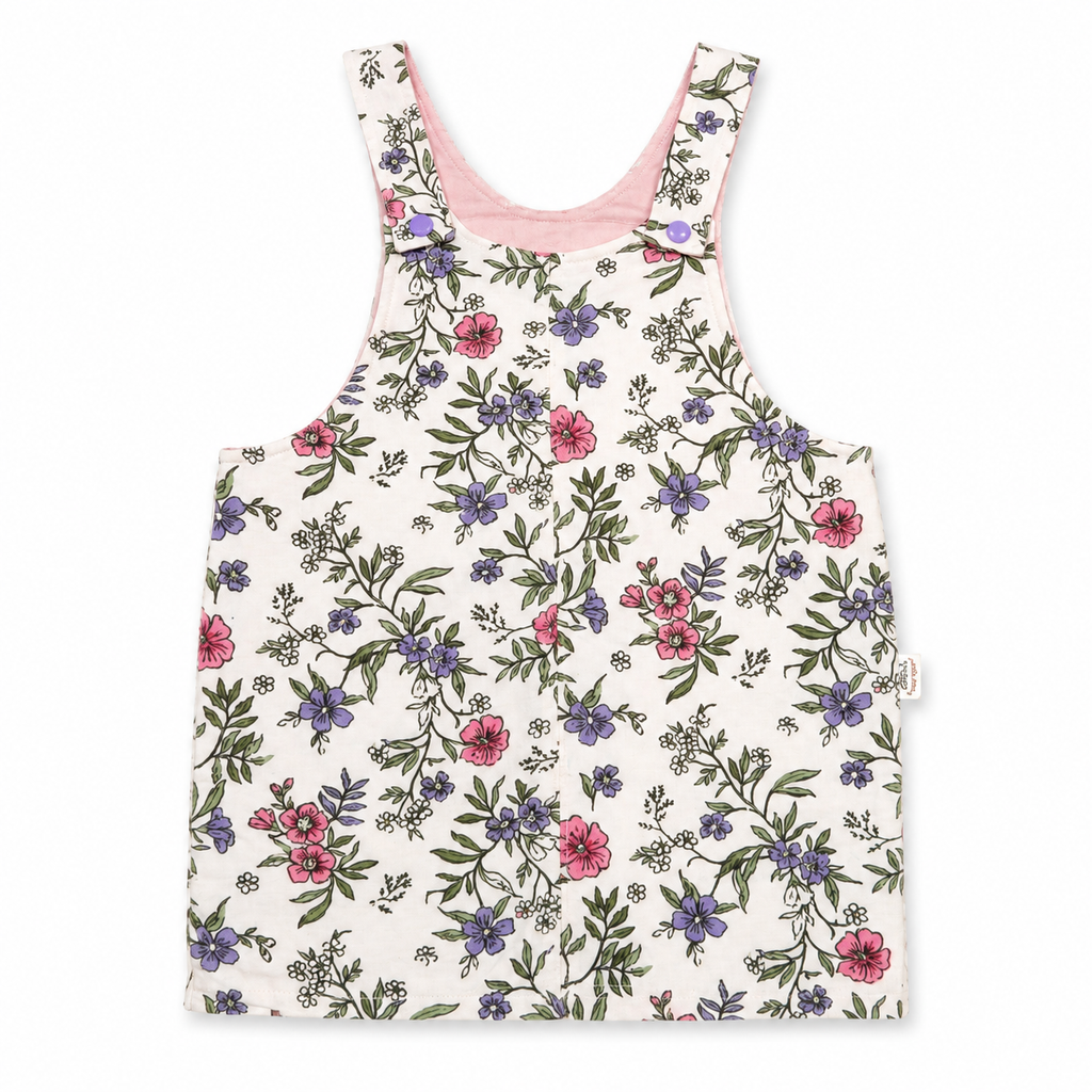 A sleeveless baby tank top with a delicate floral print on an off-white background, featuring pink and purple flowers with green leaves. It has a light pink inner collar and a small side tag.