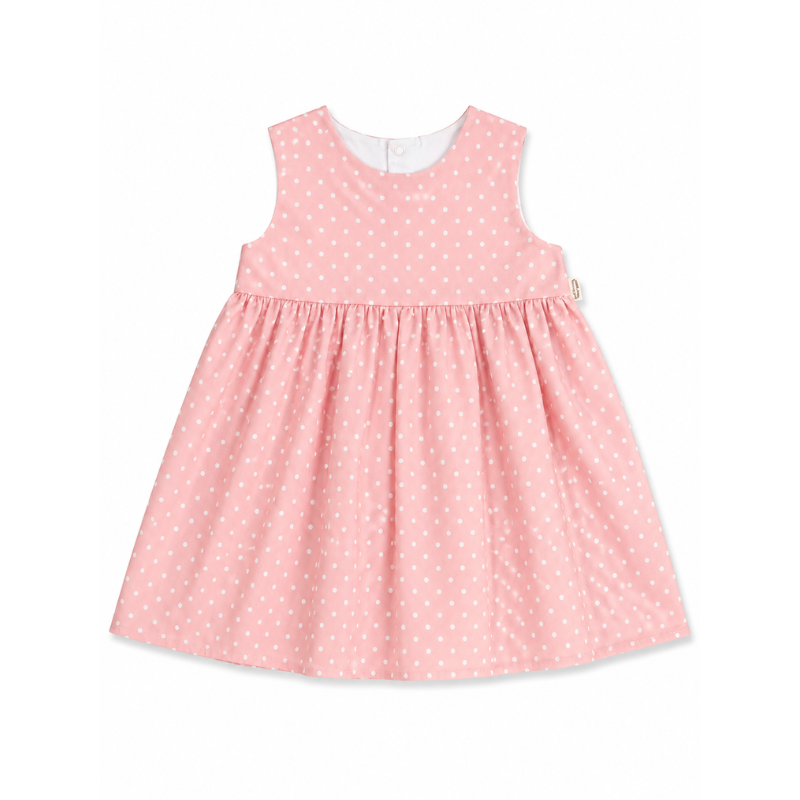 A sleeveless pink dress with a white polka dot pattern, featuring a smocked bodice and a gathered skirt, shown against a plain white background.